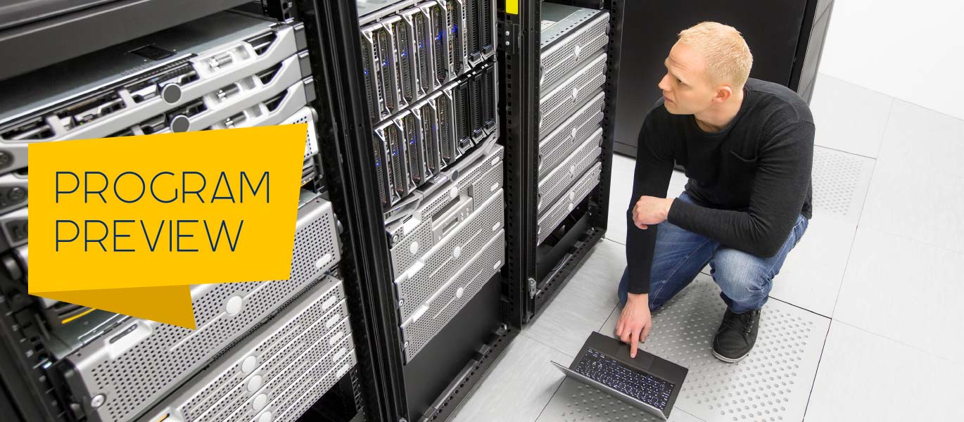 A data center technician inspects a rack of servers.