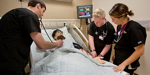 Respiratory care students practice on a mannequin in the health simulation lab.