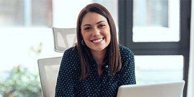 Adult female smiling while working on a laptop