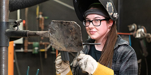 Female Welding Student working in the welding lab