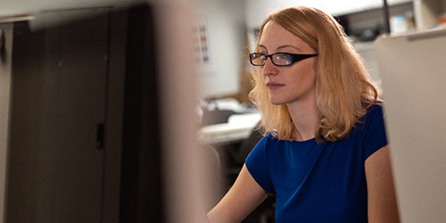 A female student works at her computer in the design lab.