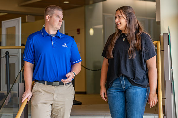 An admission rep and a student talk in the Calmar Student Center.
