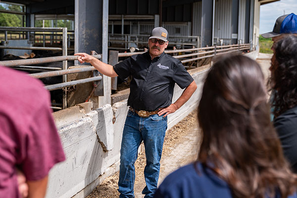An agriculture professor talks to students at the beef facility on the Calmar campus.