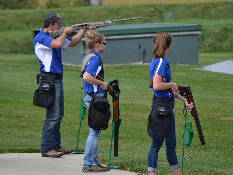 Three members of the sports shooting team aim down range.