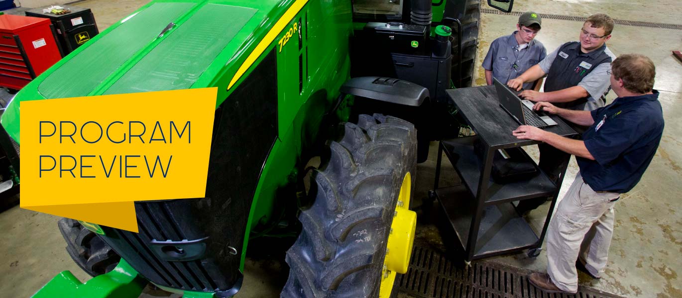 Students and an instructor gather around a computer in the John Deere TECH lab.