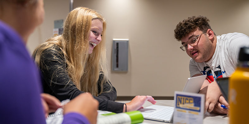 Two students working at a table in the Peosta cafeteria.