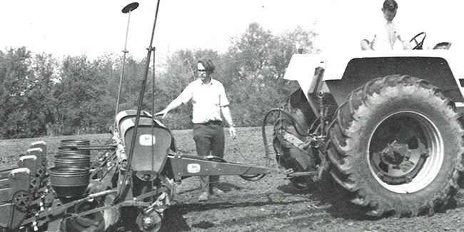 An NICC agriculture student working with a tractor in a field, 1974.