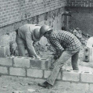 Two NICC masonry construction students working on a foundation, 1982.