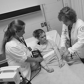 Two NICC nursing students and an instructor working in the nursing lab, 2007.