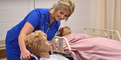 CNA student working with dummy paitent