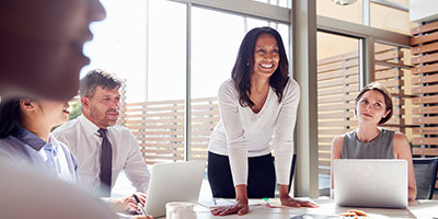 Business Woman speaking to a table of business people