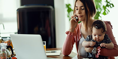 Mother tries to work online with child in her lap