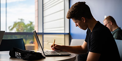 Male student working at a laptop