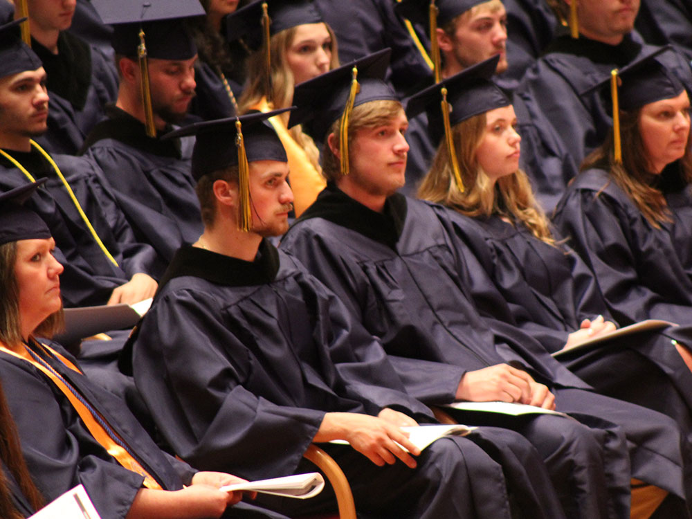 Students at the commencement ceremony wearing caps and gowns.