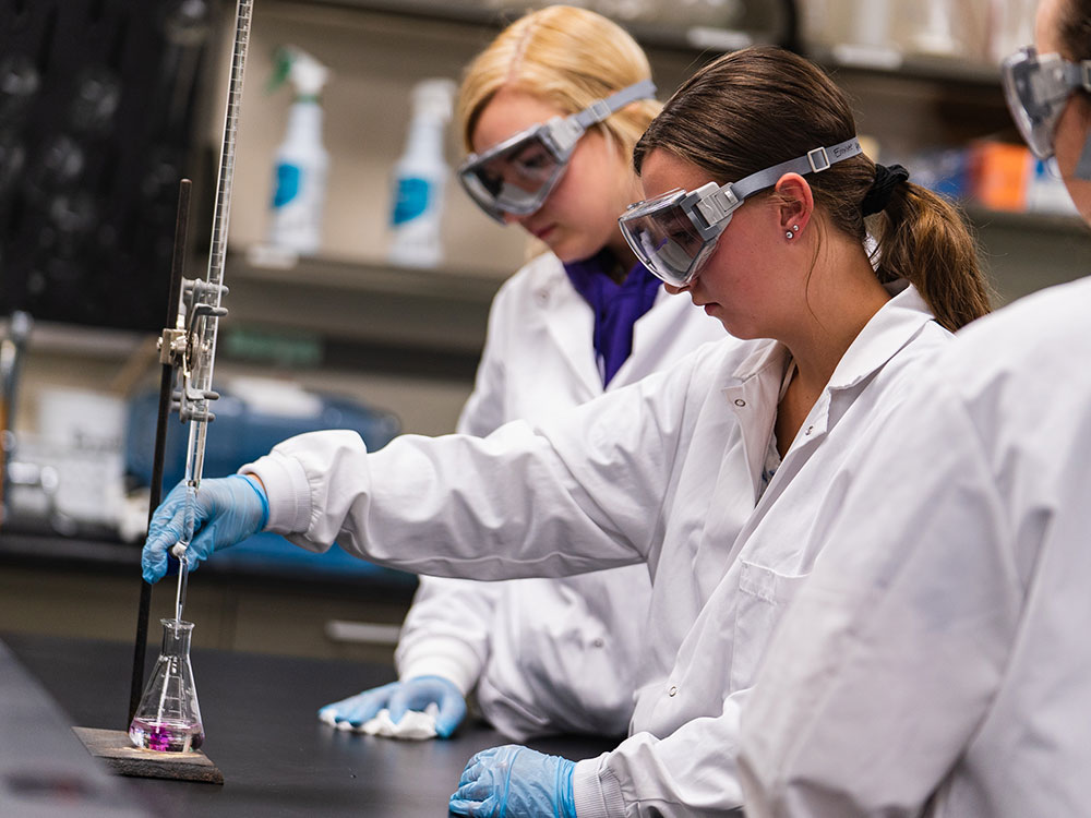 female students in a science lab using beakers