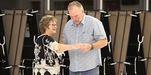 Two older adults dance together