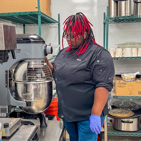 A chef working with a large mixer.
