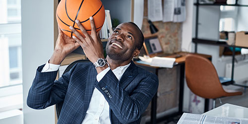 African American male in a business office with a basketball