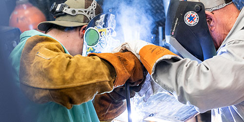 Two men welding with MIG welder