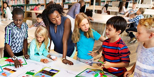 Female teacher works with a group of young children in a classroom