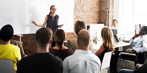 A female manager gives a presentation to her co-workers.