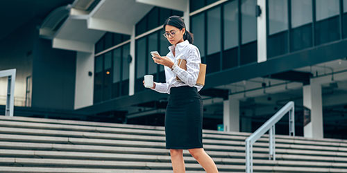 A female business professional walking up steps.