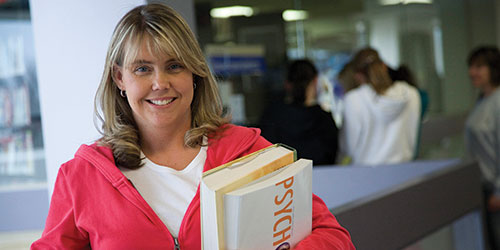 A female student holding a psychology book.