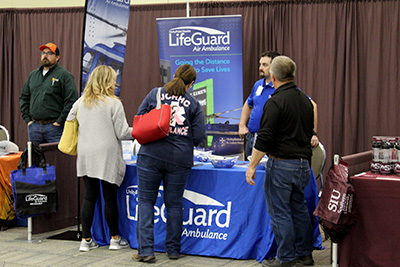 Attendees talk with a vendor in the exhibit hall.