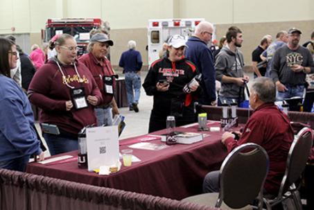 Attendees talk with a vendor in the exhibit hall.